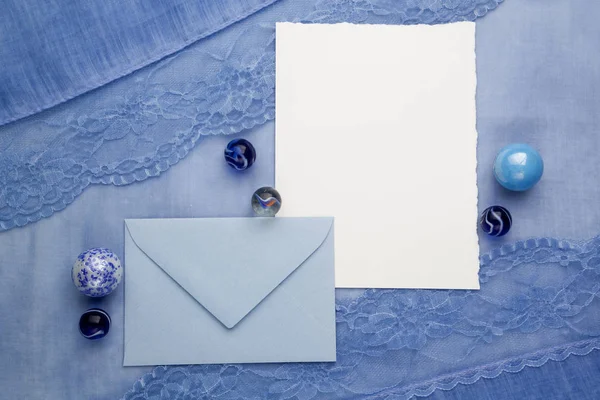 Composition de la carte de carton vide et d'une enveloppe sur fond de tissu. Couché plat, vue du dessus — Photo