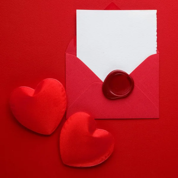 Sobre de correo, corazón y sello de cera sobre fondo rojo. Tarjeta de San Valentín, Amor o Boda Concepto de Saludo. Vista superior —  Fotos de Stock