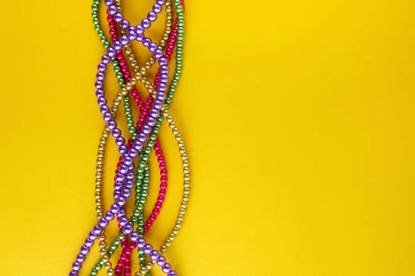 Multi color Mardi Gras beads on paper background. Top view — Stock Photo, Image