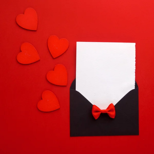 Envolvente de correo, corazón y cinta sobre fondo rojo. Tarjeta de San Valentín, Amor o Boda Concepto de Saludo. Vista superior — Foto de Stock
