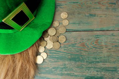 Yeşil ahşap zemin üzerine altın sikke ile mutlu St Patricks Günü cin şapka. Üstten Görünüm