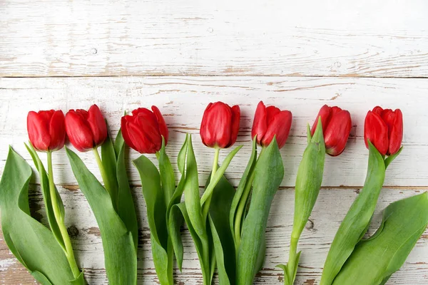 Красиві червоні тюльпани на білому дерев'яному фоні. Вид зверху . — стокове фото