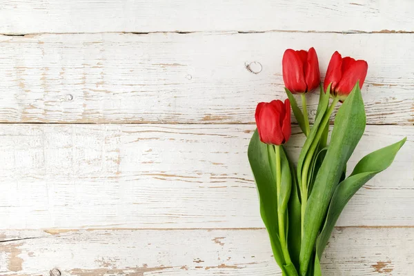 Piękne czerwone tulipany na białym tle drewnianych. Widok z góry. — Zdjęcie stockowe