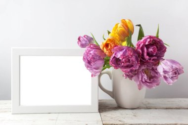 Taze Lale çiçek buketi ve ahşap arka plan üzerinde kopya alanı ile boş fotoğraf çerçevesi