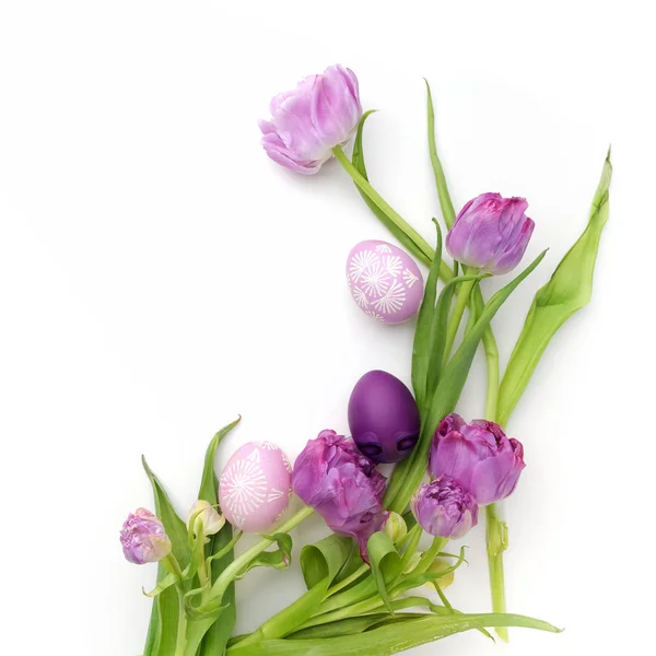 Easter eggs and tulips on white background. Flat lay. Top view — Stock Photo, Image