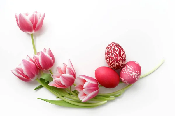 Huevos de Pascua y tulipanes sobre fondo blanco. Acostado. Vista superior —  Fotos de Stock