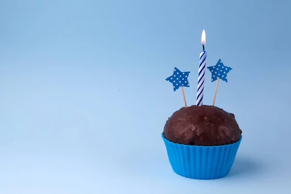 Prăjitură gustoasă cu lumânare, pe fundal albastru, cu spațiu liber — Fotografie, imagine de stoc