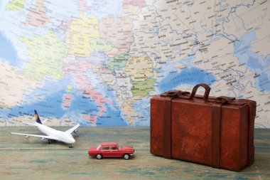 Trip or traveling by airplane concept. Miniature toy airplane and suitcases on map. clipart