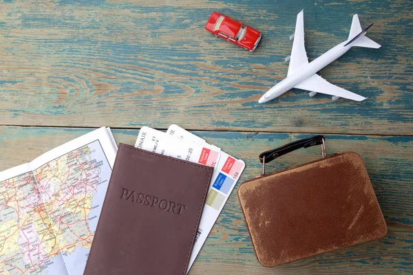 Preparación para el concepto de viaje. Dinero, pasaporte, avión, maleta y mapa sobre un fondo de madera vintage . — Foto de Stock