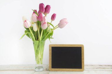 Boş resim çerçevesi üzerinde beyaz ahşap masa ile Lale