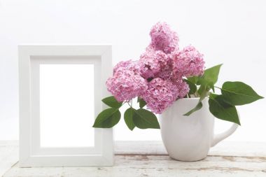 Leylak ahşap masa ve beyaz kareye kadar sahte vazoda demet