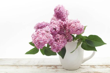 Ahşap masa üzerinde vazoda demet leylak