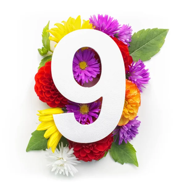 Układ z kolorowych kwiatów, liści i numer dziewięć. Leżał z płaskim. Widok z góry. — Zdjęcie stockowe