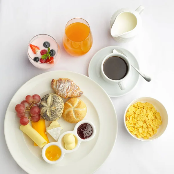 Pequeno-almoço continental rico. Croissants crostas franceses, muesli, muitas frutas doces e bagas, café quente para refeições matinais . — Fotografia de Stock