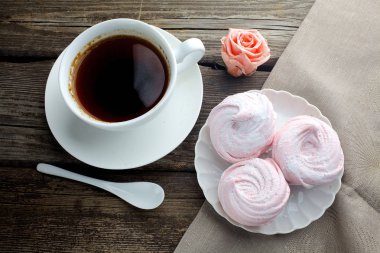 ahşap masa, üstten görünüm üzerinde siyah kahve ve hatmi tatlı ile beyaz seramik kupa