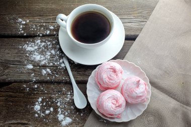 ahşap masa, üstten görünüm üzerinde siyah kahve ve hatmi tatlı ile beyaz seramik kupa