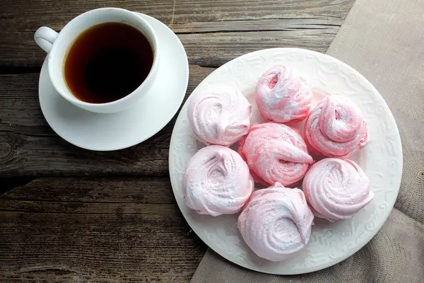 ahşap masa, üstten görünüm üzerinde siyah kahve ve hatmi tatlı ile beyaz seramik kupa