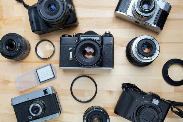 Mix van oude camera's op houten bureau achtergrond. Bovenaanzicht — Stockfoto