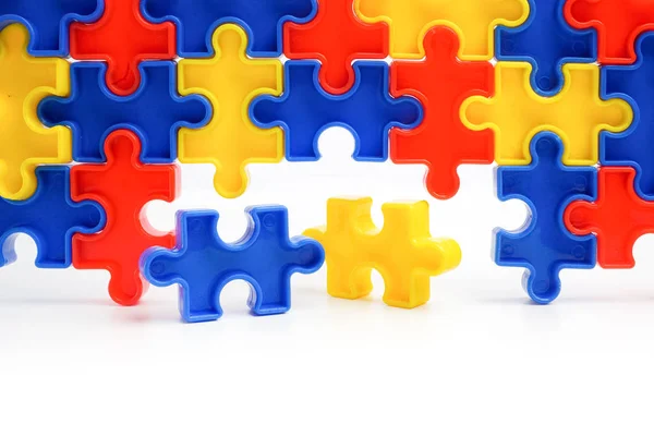 Pieces from a colorful jigsaw puzzle arranged to form a page on white background. Break barriers together for autism concept — Stock Photo, Image