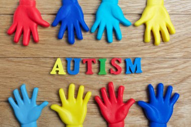 Otizm farkındalık kavramı ahşap arka plan üzerinde renkli elleri olan. Üstten Görünüm
