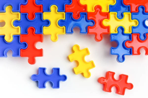 Pieces from a colorful jigsaw puzzle arranged to form a page on white background. Break barriers together for autism concept — Stock Photo, Image