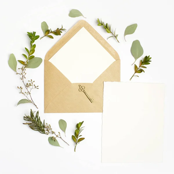 Plano tiro lay de carta e envelope de papel ecológico no fundo branco. Cartões de convite de casamento ou carta de amor com planta. Dia dos Namorados ou outro conceito de férias. Vista superior — Fotografia de Stock