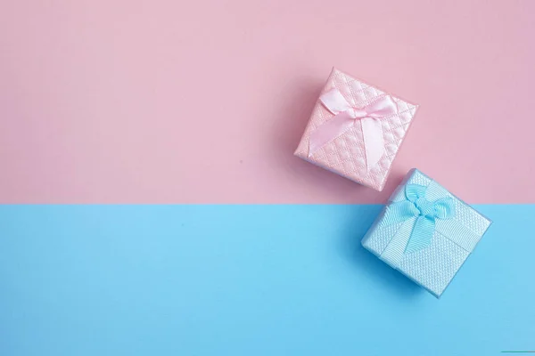 Coffrets cadeaux pour petit garçon et fille sur fond rose et bleu. Pose plate — Photo