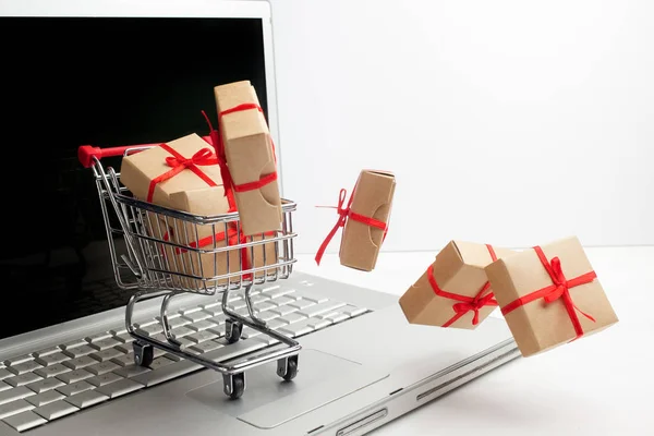 Papper lådor i en kundvagn på en laptop tangentbord. Idéer om e-handel, en transaktion för att köpa eller sälja varor eller tjänster på nätet. — Stockfoto