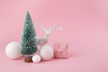 Pembe arka planda Noel süslemelerinden oluşan yaratıcı bir düzen. Tatil arkaplanı.