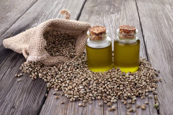 Semi di canapa e olio di canapa su tavole di legno — Foto Stock