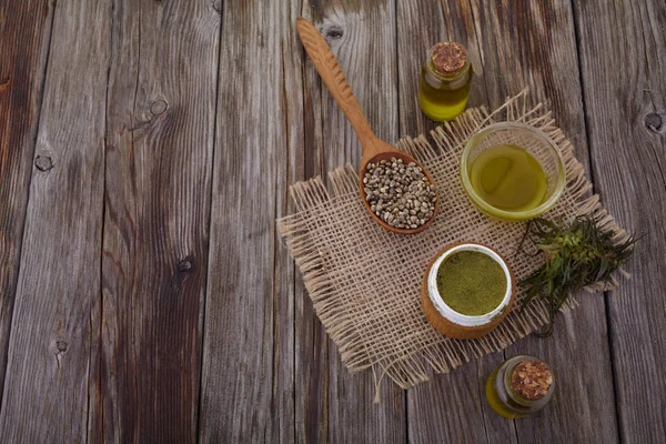 Aceite de cáñamo, polvo, semillas en la mesa de madera —  Fotos de Stock