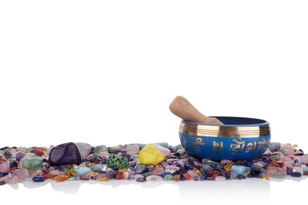 Tazón de canto tibetano y piedras de chakra curativas multicolores sobre un fondo blanco — Foto de Stock