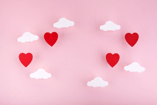 Valentines day background. Red hearts and clouds on soft pink background feel like fluffy in the air