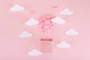 Sevgililer Günü için sevgililer günü balonu. Pembe arka planda beyaz bulutlu sıcak hava balonu tebrik kartı..