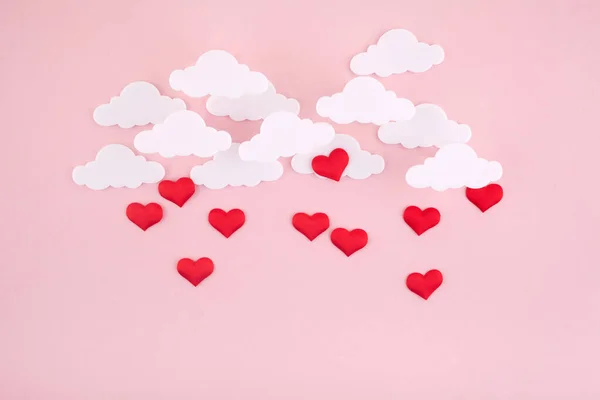 Walentynki w tle. Czerwone serca i chmury na miękkim różowym tle czuć się jak puszyste w powietrzu — Zdjęcie stockowe