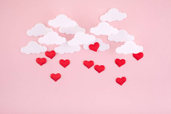 День святого Валентина фон. Красные сердца и облака на мягком розовом фоне кажутся пушистыми в воздухе
