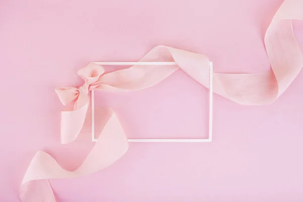 Kaart voor begroeting of felicitatie. Frame met roze lint op de roze achtergrond — Stockfoto