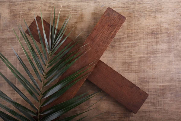 Palm Sunday. Palm brunch on wooden background with cross. Easter