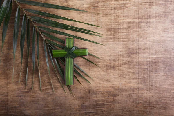 Palm sunday concept: Cross shape of palm branch on an antique wooden background — 스톡 사진