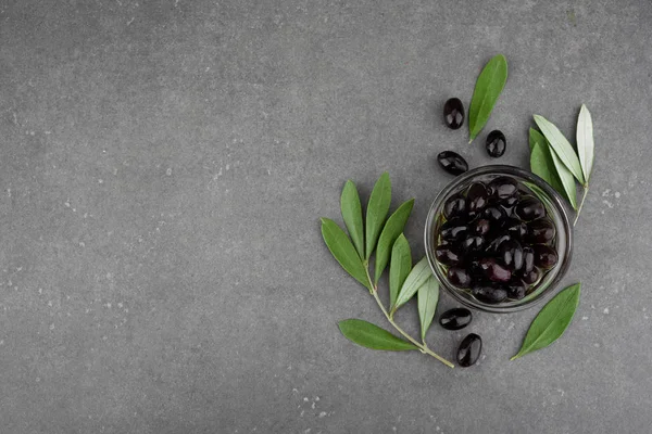 Černé olivy ve skleněné misce. Pohled shora na tmavé desce — Stock fotografie