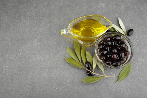 Aceite de oliva en vidrio con aceitunas negras y hojas de copyspace sobre fondo rústico — Foto de Stock