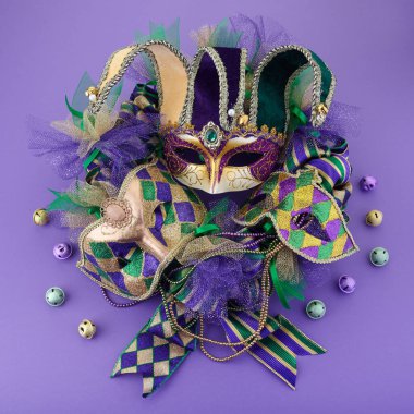 Mardi Gras çelengi mor arka planda ve Mardi Gras maskeli. Üst görünüm