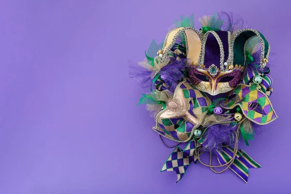 Mardi Gras çelengi mor arka planda ve Mardi Gras maskeli. Üst görünüm — Stok fotoğraf