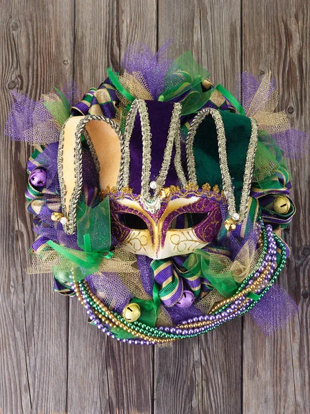 Mardi gras wieniec na starych drewnianych drzwiach z maską Mardi Gras. — Zdjęcie stockowe