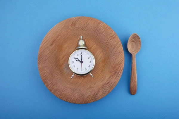 Eight hour feeding window concept or breakfast time with clock on plate and wooden spoon. Overhead view — Stock Photo, Image