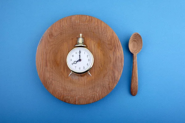 Eight hour feeding window concept or breakfast time with clock on plate and wooden spoon. Overhead view — 스톡 사진