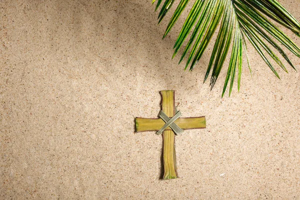 Хрест і пальмове дерево листя на піску. Концепція "Палм неділя". Вид зверху — стокове фото