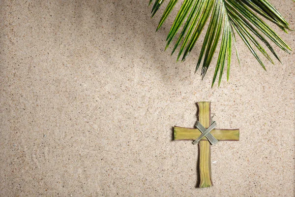 Kruis en Palmboom Bladeren op zand. Palmzondag concept. Bovenaanzicht — Stockfoto