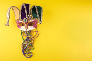 Sarı arka planda renkli bir Mardi Gras ya da karnaval maskesi. Venedik maskeleri.
