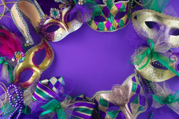 紫色の背景にコピースペースのフレームを作るマルディグラマスクのグループ — ストック写真